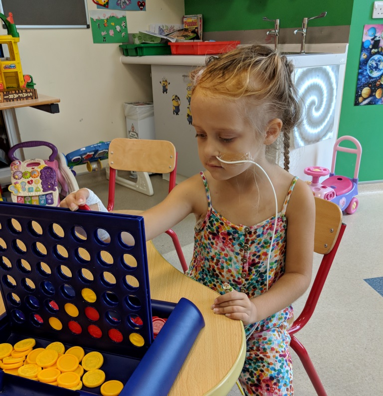 Patient with brain tumour at Royal Manchester Children's Hospital charity playing Connect 4
