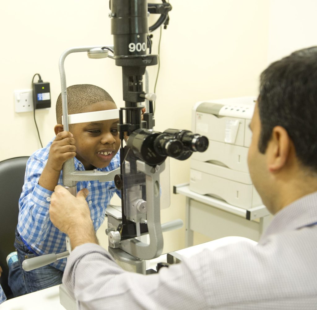 Child looks through opticians equipment