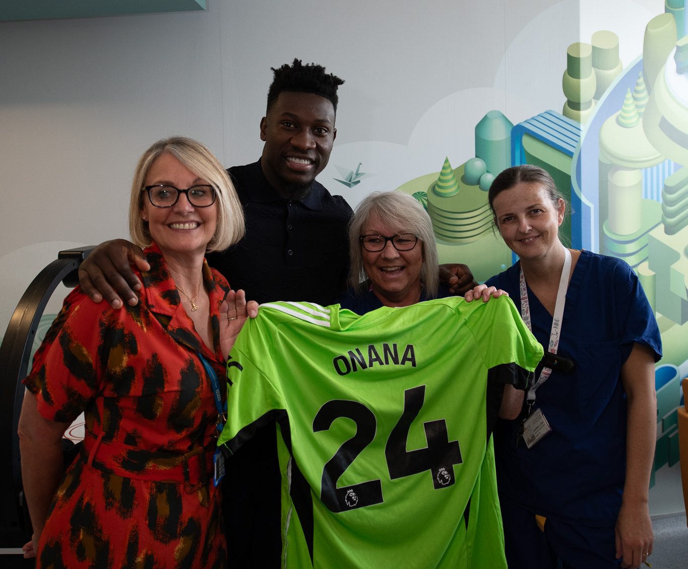 Andre Onana poses with Royal Manchester Children's Hospital CEO and staff along with new gowns he donated