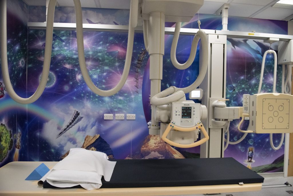 Radiology room with space themed artwork and medical equipment