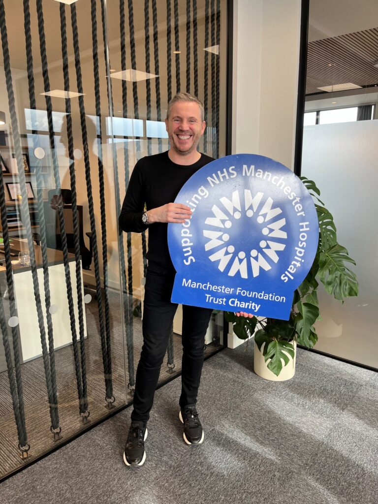 Brianstanding in office holding Charity logo